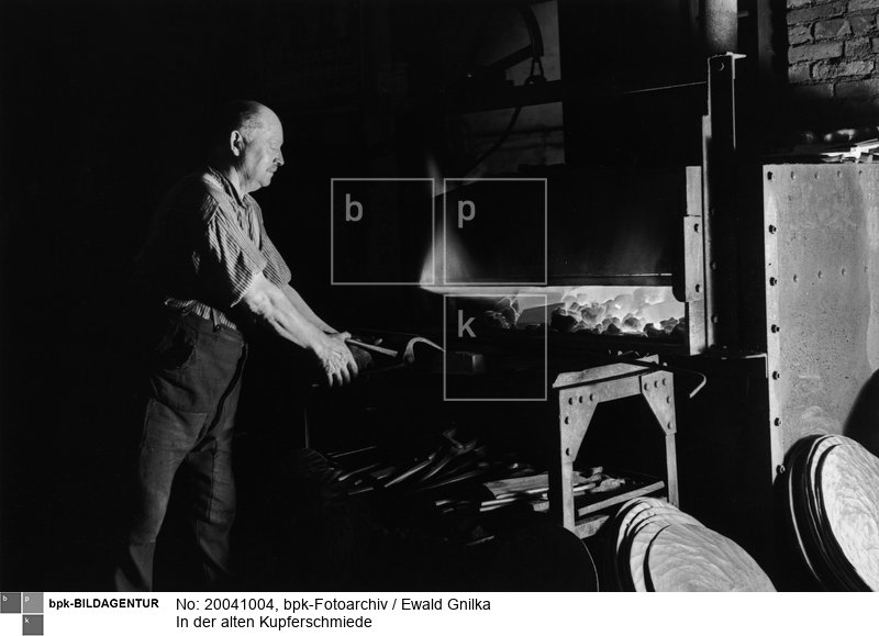 Fotograf: Ewald Gnilka <BR> Die Kupferbarren werden im Schmiedefeuer erhitzt. <BR> Motiv 4 von 11 <BR> Aufnahmedatum: um 1930 <BR> Inventar-Nr.: Gk 2610 <BR> Systematik:  <BR> Kulturgeschichte / Handwerk / Metallgewerbe / Schmied / Kupferschmied