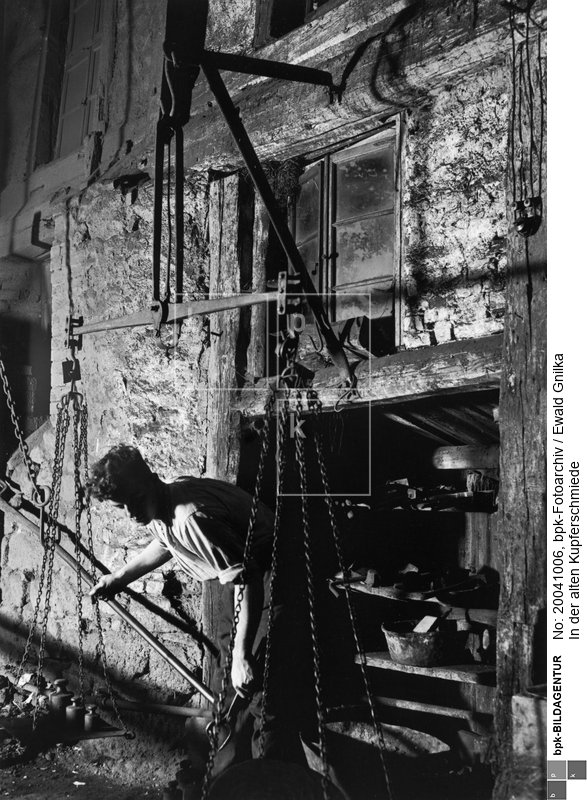 Fotograf: Ewald Gnilka <BR> An der Waage wird das benötigte Material abgewogen. <BR> Motiv 6 von 11 <BR> Aufnahmedatum: um 1930 <BR> Inventar-Nr.: Gk 2613 <BR> Systematik:  <BR> Kulturgeschichte / Handwerk / Metallgewerbe / Schmied / Kupferschmied