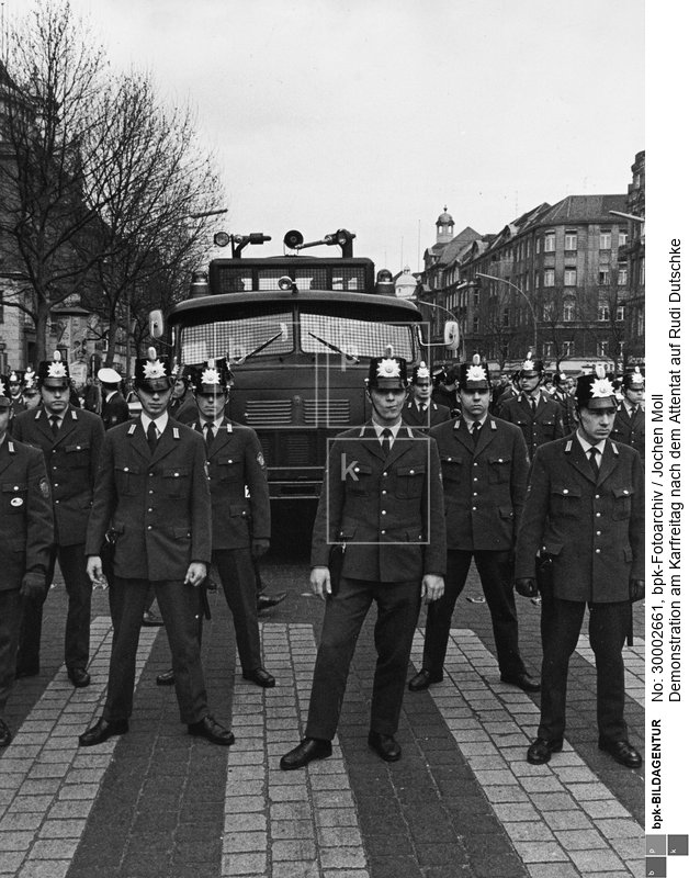 Die Polizei wartet schon.<BR>Aufnahmedatum: 12.04.1968<BR>Aufnahmeort: Berlin (West)<BR>Inventar-Nr.: Mo 1007-75<BR>Systematik: <BR>Geschichte / Deutschland / 20. Jh. / West-Berlin 1949-1990 / Gesellschaftliche Bewegungen / Außerparlamentarische Opposition  / Demonstrationen, Proteste / Attentat auf Dutschke