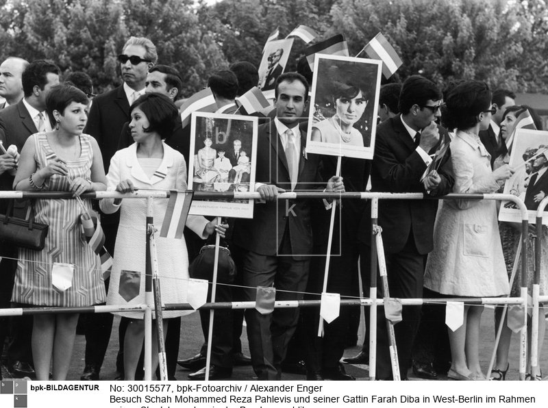 Sogenannte "Jubelperser" begrüßen das Schahpaar am Straßenrand während der Fahrt zur Deutschen Oper.<BR>Aufnahmedatum: 02.06.1967<BR>Aufnahmeort: Berlin (West)<BR>Inventar-Nr.: Eg 67/160/1-07<BR>Systematik: <BR>Geschichte / Deutschland / 20. Jh. / West-Berlin 1949-1990 / Außenbeziehungen / Asien / Iran / Besuche in Berlin / Schah 1967