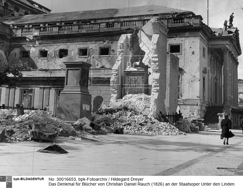 Es steht noch zur Hälfte in der Ummauerung, die es vor der Zerstörung durch Luftangriffe bewahren sollte. Das Denkmal für York (vorn) fehlt, dasjenige für Gneisenau (hinten) ist noch eingemauert.<BR>Aufnahmedatum: 1945<BR>Aufnahmeort: Berlin<BR>Inventar-Nr.: Dr 2471a<BR>Systematik: <BR>Geschichte / Deutschland / 20. Jh. / Nachkriegszeit: Berlin 1945-49 / Kriegszerstörungen / Ruinen / Denkmäler / Unter den Linden