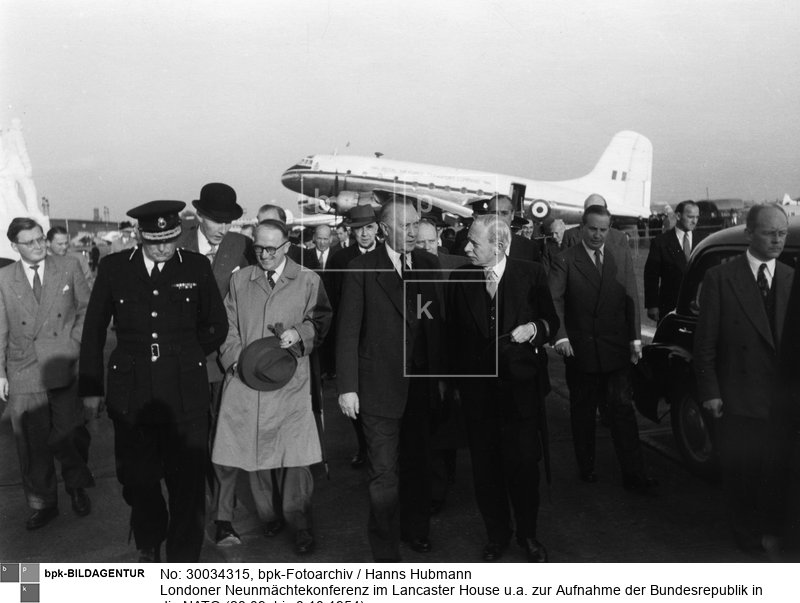 Ankunft der deutschen Delegation. Bundeskanzler Adenauer (Mitte) im Gespräch mit dem britischen Außenminister Eden. Links neben Adenauer, mit Brille, Staatssekretär Hallstein<BR>Aufnahmedatum: 28.09.1954<BR>Material/Technik: Foto<BR>Aufnahmeort: London<BR>Inventar-Nr.: Hu 6790-31A<BR>
