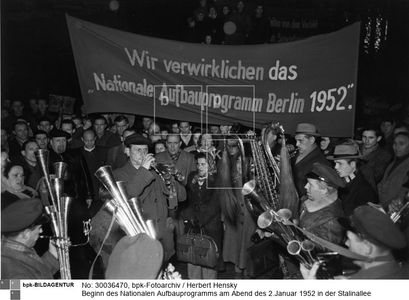 Aufbauhelfer, unter ihnen auch Walter Ulbricht (links), werden mit Musik begrüßt <br> Aufnahmedatum: 02.01.1952 <br> Aufnahmeort: Berlin (Ost) <br> Inventar-Nr.: Hy 0518/1222-10A <br> Systematik:  <br> Geschichte / Deutschland / 20. Jh. / DDR / Städtebau / Kriegszerstörungen / Wiederaufbau / Allgemeines / Nationales Aufbauwerk
