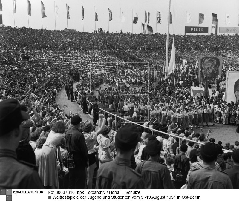 Fotograf: Horst E. Schulze <BR> Einmarsch der Teilnehmer in das Walter-Ulbricht-Stadion während der Eröffnungsfeier <BR> Aufnahmedatum: August 1951 <BR> Aufnahmeort: Berlin (Ost) <BR> Inventar-Nr.: Sz 1951/34/07-09 <BR> Systematik:  <BR> Geschichte / Deutschland / 20. Jh. / DDR / Bevölkerung / Jugendliche / FDJ / Weltfestspiele / 1951