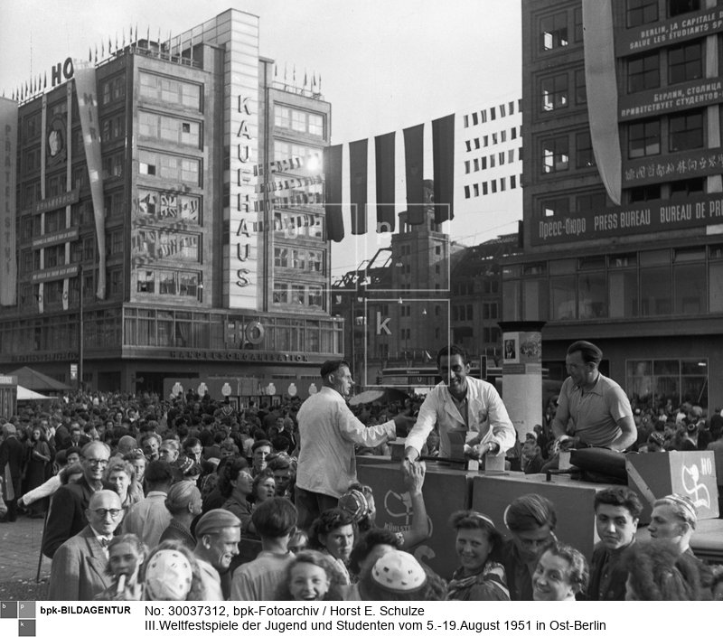Fotograf: Horst E. Schulze <BR> Eisverkäufer auf dem geschmückten Alexanderplatz <BR> Aufnahmedatum: August 1951 <BR> Aufnahmeort: Berlin (Ost) <BR> Inventar-Nr.: Sz 1951/34/13-05 <BR> Systematik:  <BR> Geschichte / Deutschland / 20. Jh. / DDR / Bevölkerung / Jugendliche / FDJ / Weltfestspiele / 1951