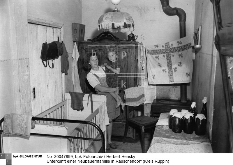 Fotograf: Herbert Hensky <BR> Mutter mit kleiner Tochter in einem Zimmer <BR> Motiv 1 von 4 <BR> Aufnahmedatum: Juli 1950 <BR> Aufnahmeort: Rauschendorf (Kreis Ruppin) <BR> Inventar-Nr.: Hy 0429/0821-11 <BR> Systematik:  <BR> Geschichte / Deutschland / 20. Jh. / DDR / Städtebau / Städte / Wohnungen / Slums, Elendswohnungen / Baracken, Notunterkünfte