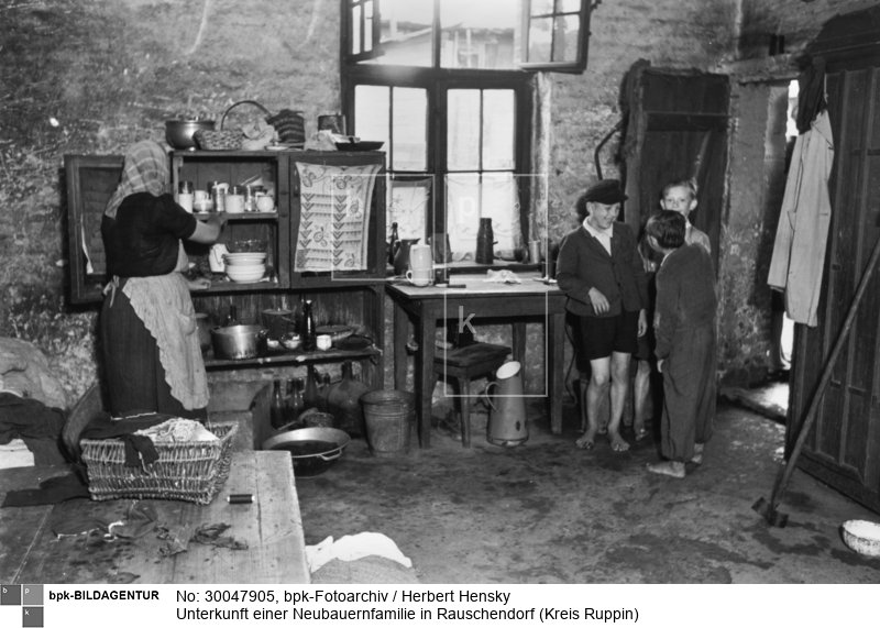 Fotograf: Herbert Hensky <BR> Die Küche, in der auch Schlafplätze für Kinder untergebracht sind <BR> Motiv 4 von 4 <BR> Aufnahmedatum: Juli 1950 <BR> Aufnahmeort: Rauschendorf (Kreis Ruppin) <BR> Inventar-Nr.: Hy 0429/0821-20 <BR> Systematik:  <BR> Geschichte / Deutschland / 20. Jh. / DDR / Städtebau / Städte / Wohnungen / Slums, Elendswohnungen / Baracken, Notunterkünfte
