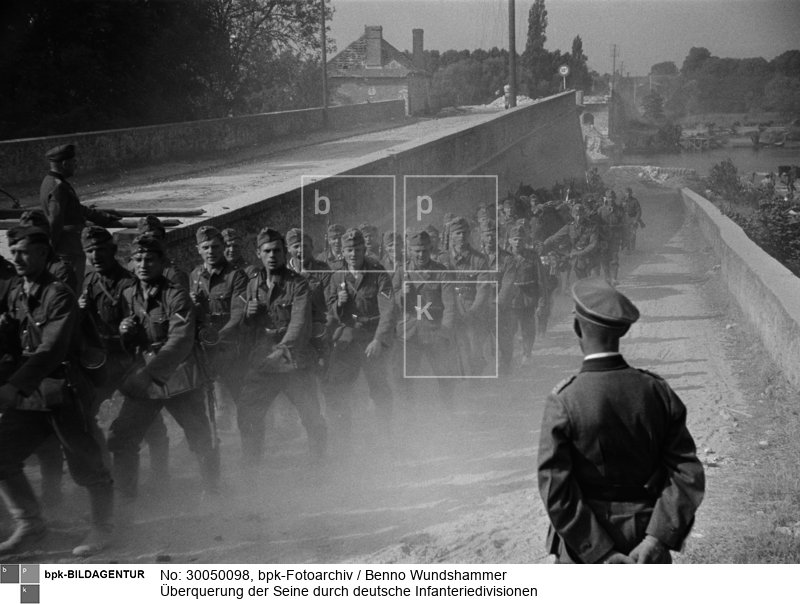 hier: zerstörte Brücke, an Regimentskommandeuren vorbeiziehende Truppen<BR>Aufnahmedatum: 15.06.1940<BR>Material/Technik: Foto<BR>Aufnahmeort: Les Andelys (Umgebung), Normandie, Frankreich<BR>Inventar-Nr.: Wu WII24-15A<BR>