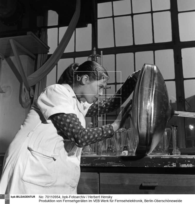 Mit Augen und Fingerspitzen werden Bildröhren auf eventuelle Mängel untersucht<BR>Aufnahmedatum: Februar 1959<BR>Material/Technik: Foto<BR>Aufnahmeort: Berlin (Ost)<BR>Inventar-Nr.: Hy 0969/3379-09