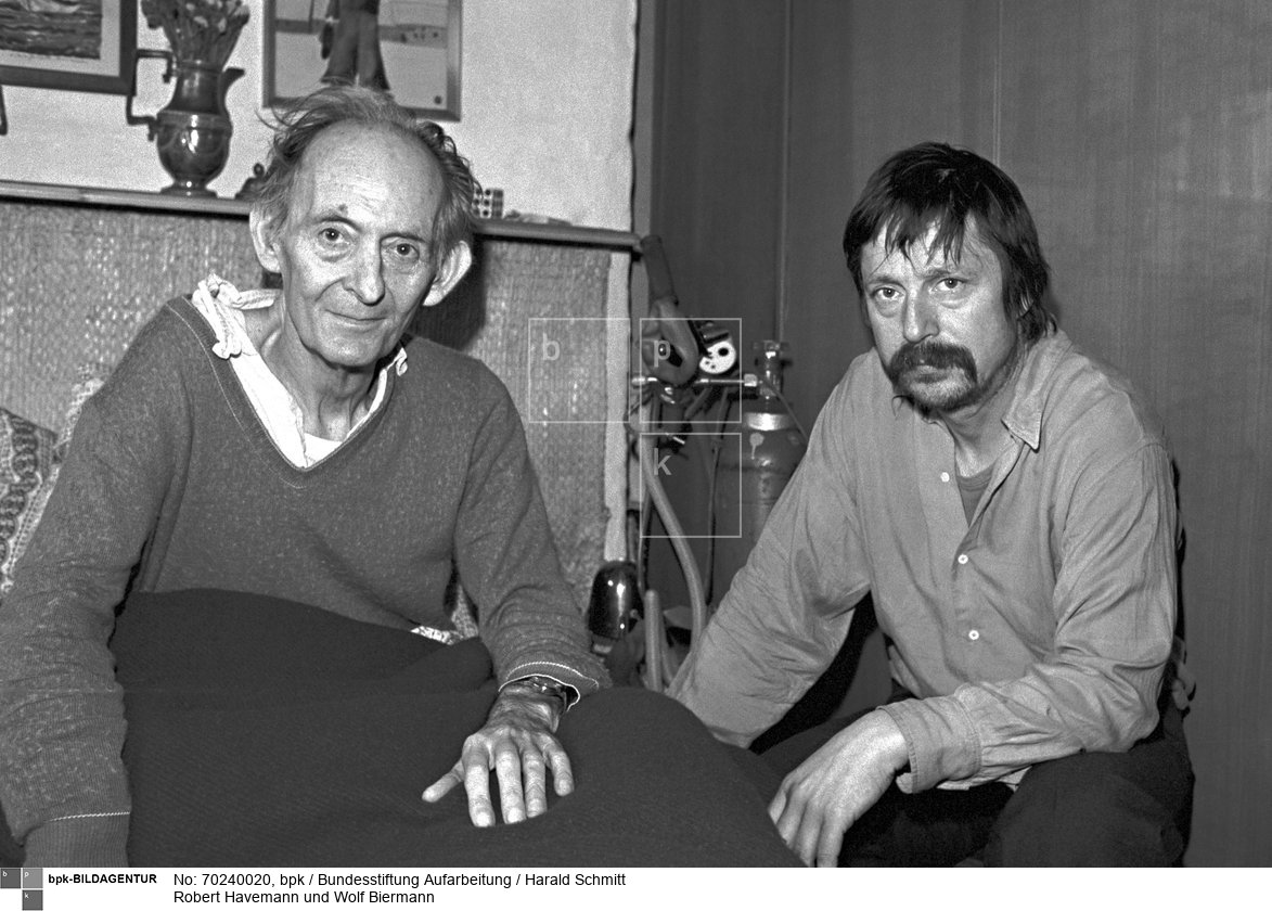 DDR - Der Sänger Wolf BIERMANN besucht den todkranken Regimekritiker Robert HAVEMANN an dessen Bett in seinem Haus in Grünheide bei Berlin. Die DDR Behörden haben Gnade vor Recht ergehen lassen und haben Biermann, heimlich, die Einreise gestattet. Film: 82 0401  Negativ: 4<BR>Person: Biermann, Wolf, [15.11.1936 - ], deutscher Liedermacher und Lyriker Havemann, Robert, [11.03.1910 - 09.04.1982], deutscher Regimekritiker der DDR<BR>Aufnahmedatum: 1982<BR>Material/Technik: Foto<BR>Aufnahmeort: Grünheide (Mark) / DDR (Deutschland)<BR>Inventar-Nr.: Schmitt_348ret