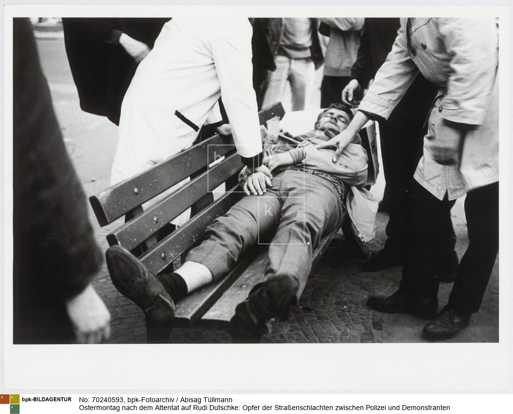 Rückseitenbeschriftung von anderer Hand: "Ffm, Ostermontag '68. Verletzter"<BR>Aufnahmedatum: 15.04.1968<BR>Material/Technik: Foto / Silbergelatine auf Barytpapier<BR>Bildformat (Foto): 30,3 x 39,7 cm<BR>Aufnahmeort: Frankfurt am Main / Deutschland<BR>Inventar-Nr.: Tü 68/048-20<BR>