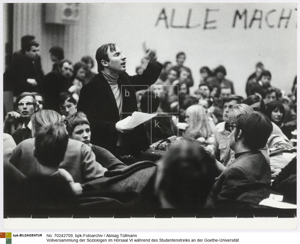 Hans-Jürgen Krahl spricht. Parole an der Wand: "Alle Macht den Räten!"
Rückseitenbeschriftung von anderer Hand: "Hans-Jürgen Krahl, 1968"<BR>Aufnahmedatum: Dezember 1968<BR>Material/Technik: Foto / Silbergelatine auf Barytpapier<BR>Bildformat (Foto): 23,3 x 30,4 cm<BR>Aufnahmeort: Frankfurt am Main / Deutschland<BR>Inventar-Nr.: Tü 68/328-02<BR>