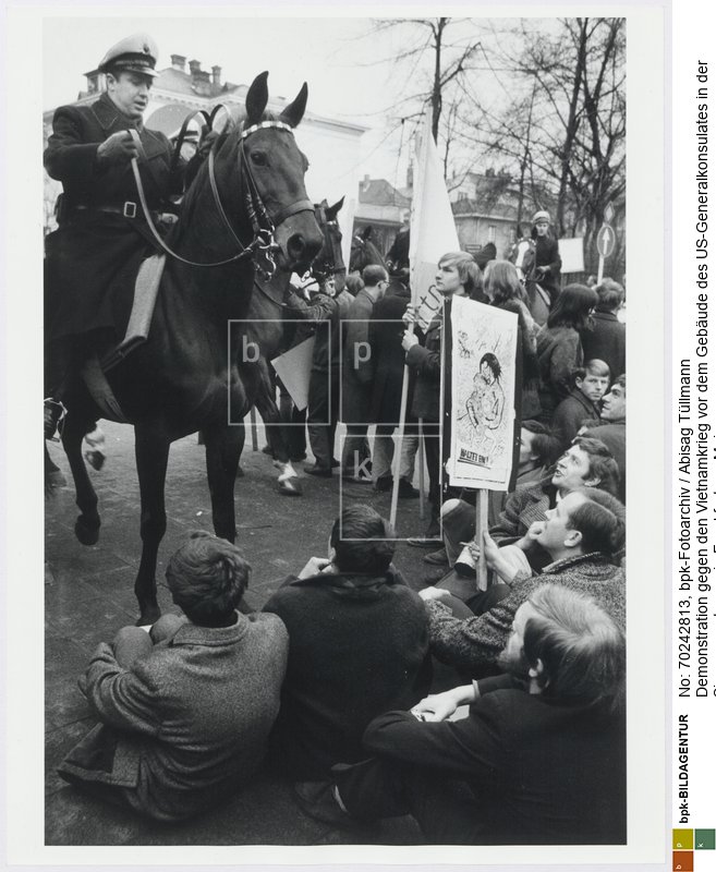 Rückseitenbeschriftung von Hand der Fotografin: "Demonstration gegen den Vietnamkrieg vor dem Generalkonsulat der USA, Siesmeyerstraße, Ffm, Febr. 1967"<BR>Aufnahmedatum: Februar 1967<BR>Material/Technik: Foto / Silbergelatine auf Barytpapier<BR>Bildformat (Foto): 39,4 x 30,3 cm<BR>Aufnahmeort: Frankfurt am Main / Deutschland<BR>Inventar-Nr.: Tü 67/020-60<BR>