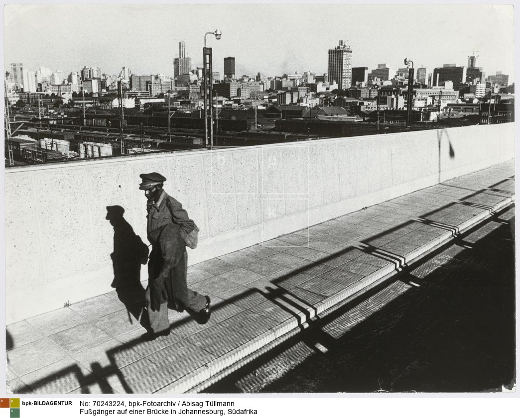 Im Hintergrund Bahngleise und Hochhäuser der Großstadt
Rückseitenbeschriftung von Hand der Fotografin: "Johannesburg"<BR>Aufnahmedatum: Oktober 1971<BR>Material/Technik: Foto / Silbergelatine auf Barytpapier<BR>Bildformat (Foto): 30,3 x 40 cm<BR>Aufnahmeort: Johannesburg / Südafrika<BR>Inventar-Nr.: Tü 71/240-19<BR>
