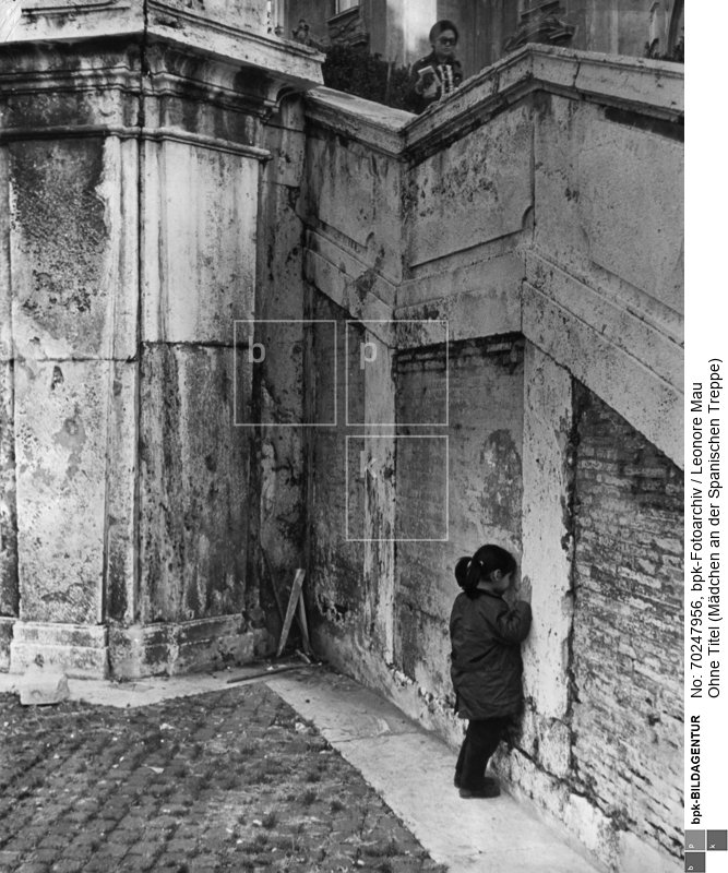 Ein junges Mädchen mit Zöpfen steht vor einer Wand der Spanischen Treppe. Ihre Hände und Kopf hält sie gegen die Wand. Im Hintergrund läuft eine Frau mit Sonnenbrille die Treppe runter.
Referenz: Ronald Kay, Die Kinder Herodots, S. Fischer Verlag GmbH, 2006
Rückseitenbeschriftung: "ROM SPAN. TREPPE"<BR>Aufnahmedatum: November 1967 - April 1968<BR>Material/Technik: Foto / Silbergelatine auf Barytpapier<BR>Bildformat (Foto): 23,4 x 29,8 cm<BR>Aufnahmeort: Rom<BR>Inventar-Nr.: LM-506600<BR>