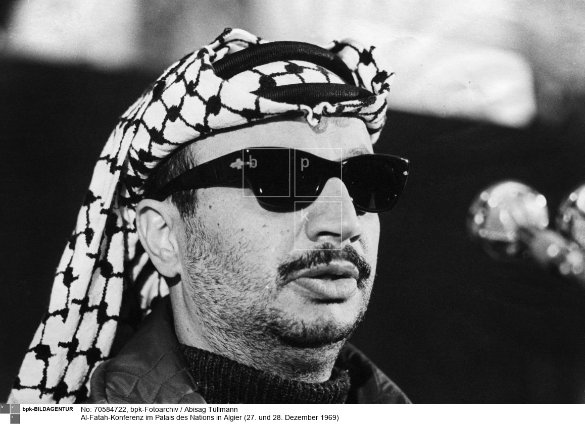 Rückseitenbeschriftung:"Algerien 27. u. 28.12.1969, Al-Fatah-Konferenz im Palais des Nations in Algier: Yassir Arafat spricht."<BR>Aufnahmedatum: Dezember 1969<BR>Material/Technik: Foto / Silbergelatine<BR>Bildformat (Foto): 20,2 x 29,3 cm<BR>Aufnahmeort: Algier / Algerien<BR>Inventar-Nr.: Tü 69/400-12<BR>