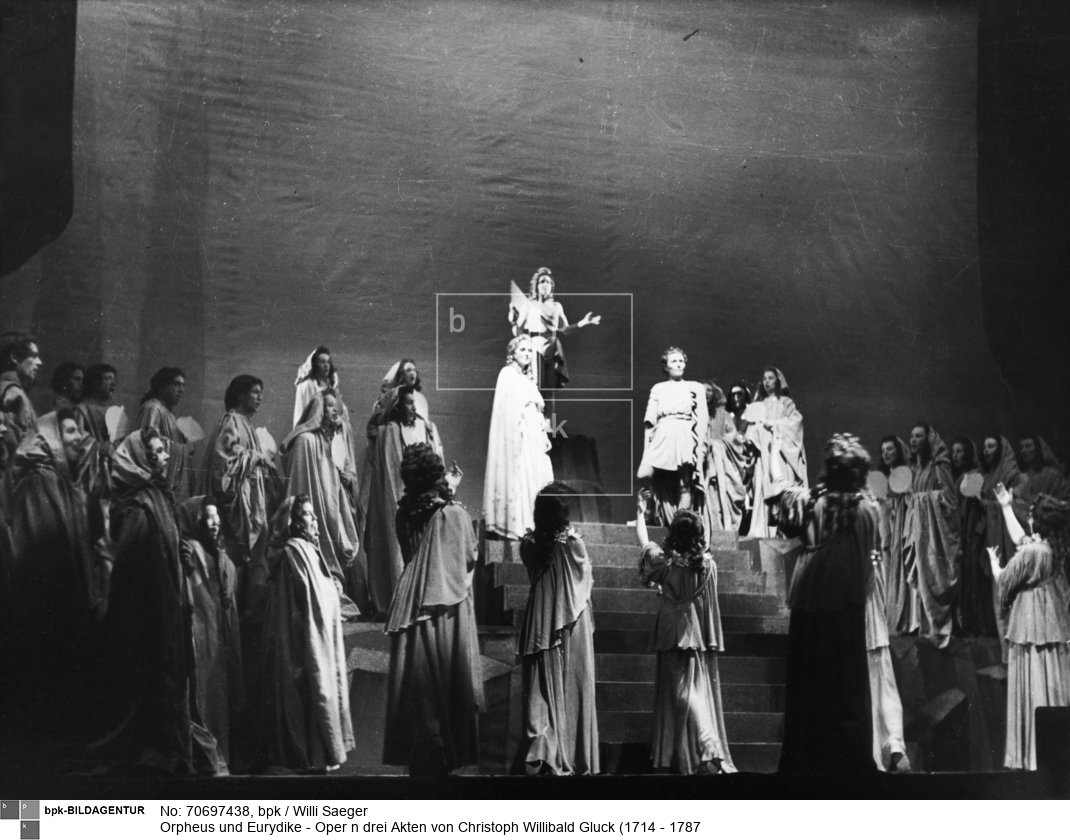 Aufführung an der Deutschen Oper Berlin;
Szenenbild: oben mit Ilse Menzel als Eros (Amore/L’Amour/Amor), Tiana Lemnitz als Eurydike und Anneliese Müller (Alt) als Orpheus (Orfeo/Orphée)
Musikalische Leitung: Karl Schmidt
Inszenierung: Wolf Völker
Bühnenbild: Robert Hereth (Herlth?)<BR>Aufnahmedatum: September 1945 <BR>Material/Technik: Foto<BR>Aufnahmeort: Berlin (West)<BR>