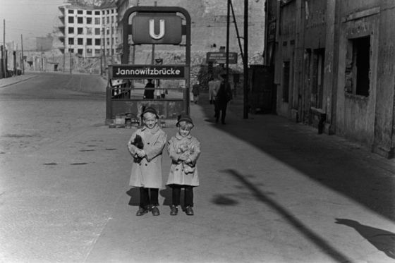 Zwei kleine Kinder mit Stofftieren in der Brückenstraße vor dem Eingang zum U-Bahnhof Jannowitzbrücke