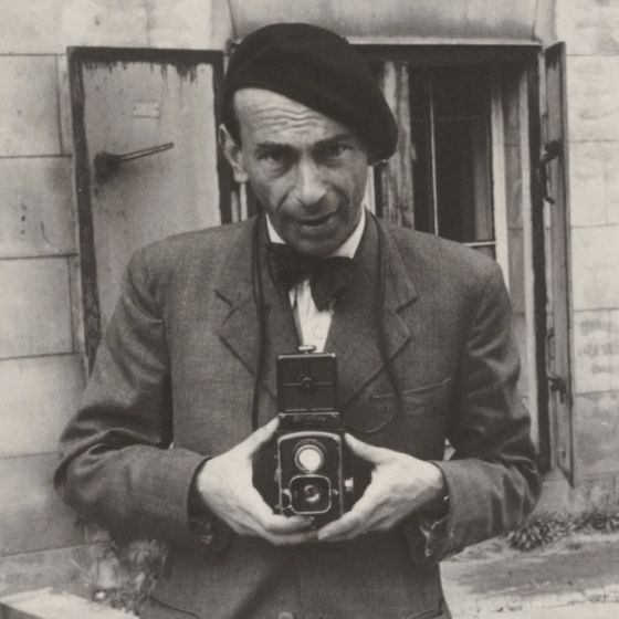 Der Fotograf Fritz Eschen mit einer Fotokamera in den Händen